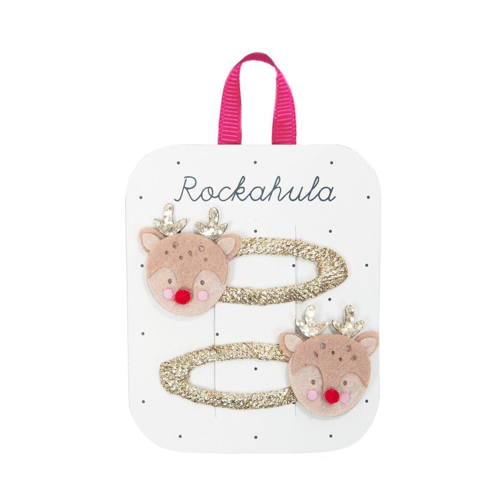 Twee goudkleurige haarclips met rendierkopjes, glitterend gewei en rode pomponneuzen op een witte kaart.