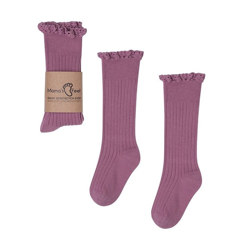 Mama's Feet Mono Baby kniekousen in mauve met ribstructuur en kanten ruches, los en met papieren wikkel.