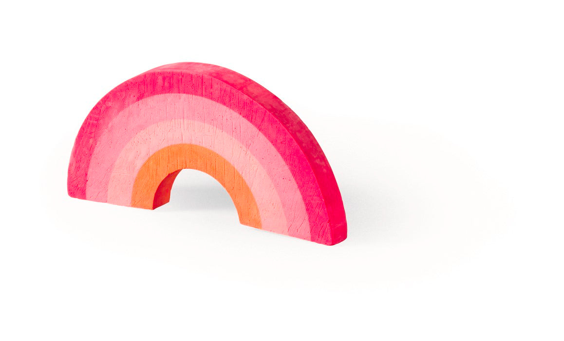 Regenboogvormig stoepkrijt met rode, roze en oranje banen op een witte achtergrond.