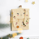 Crèmekleurige konijnenadventskalender aan de muur, versierd met haaraccessoires en sleutelhangers.