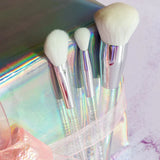 Blusher Brush uit de Camille-collectie naast twee kleinere make-upkwasten in een holografische verpakking met strik.