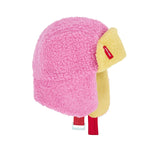 Cozy Kira kindermuts in roze en geel met oorkleppen en rode kinband, van opzij gezien.