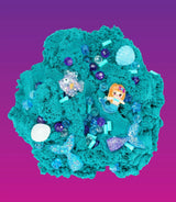 Groenblauw Mermaid Magic wolkenslijm met zeemeermin, staarten, schelpen en kralen op een paarsroze achtergrond.