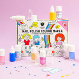 Nailmatic DIY-nagellakset met gekleurde flesjes en glitters rond de doos op een roze achtergrond.