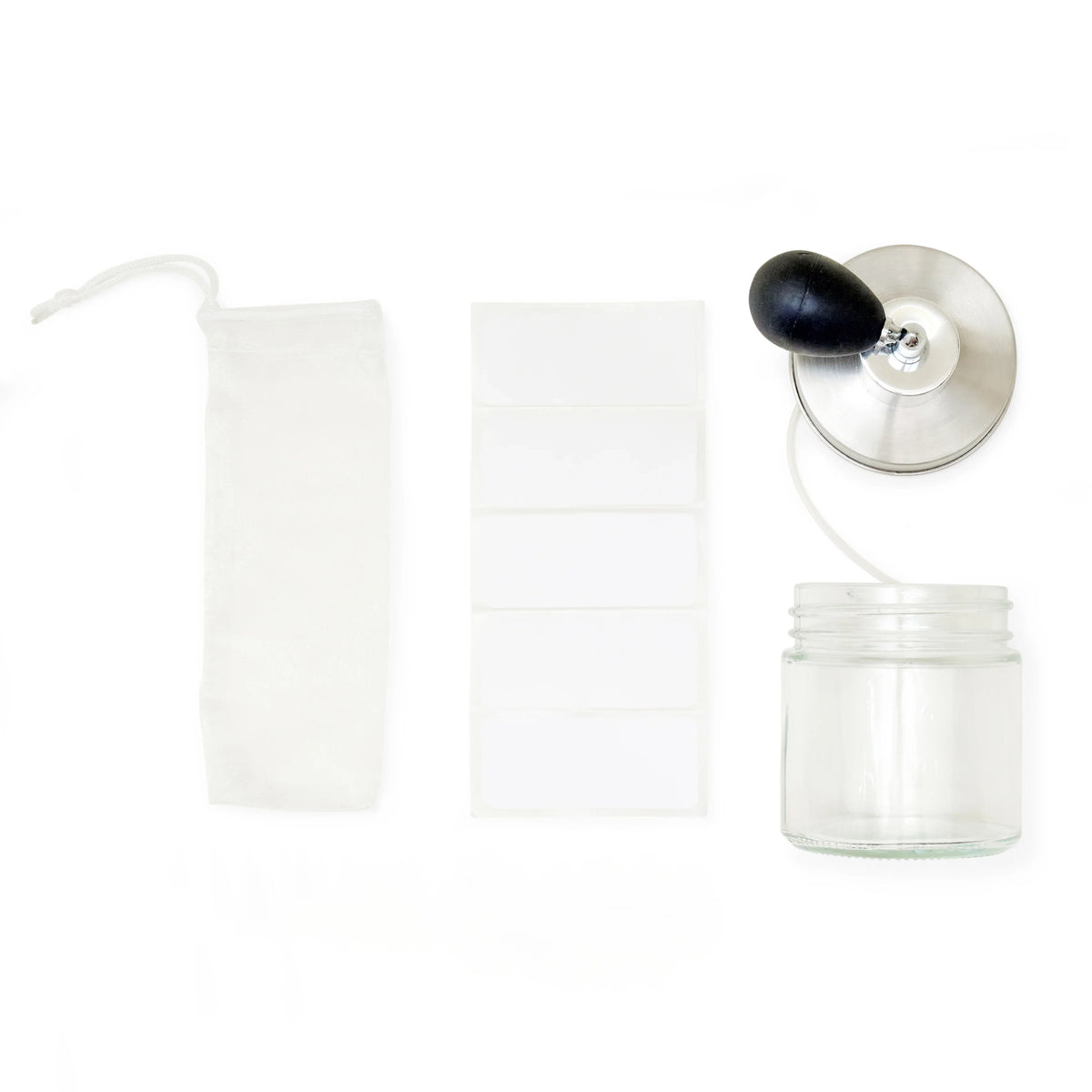 DIY-parfumset met transparant flesje, zilverkleurige verstuiver met zwarte knijpbal, wit gaaszakje en stickerlabels