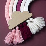Detail van de regenboog Mono Roze met een kartonnen wolk en roze, bordeauxrode en witte kwastjes