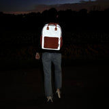 Flashbag Charlie rugzak op de rug van een persoon in het donker, met fel oplichtende reflecterende stof.