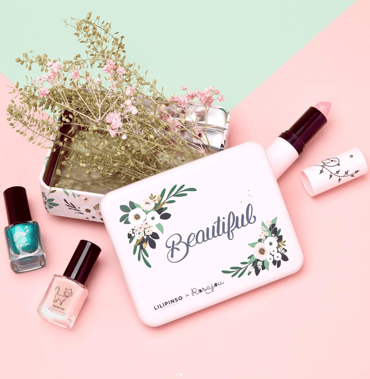 Rosajou Wonderland cadeauset met roze bloemendoosje, roze lippenstift en twee kleuren nagellak naast droogbloemen