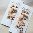 Twee sets Summer Vibes haarspeldjes in zachte roze tinten met bloem, bolletjes, pompon, blaadjes en strik op kaartjes.