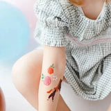 Kindertattoos met een paard en roze en oranje bloemen op de onderarm van een kind.