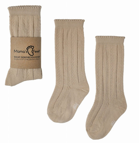 Beige Helen kniekousen van Mama's Feet met opengewerkt patroon, los en met papieren wikkel.
