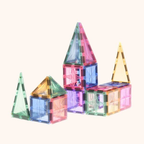 Coblo magnetische bouwblokken in transparante pastelkleuren, opgebouwd tot huisjes en torens met puntdaken.