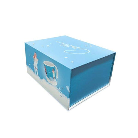 Gesloten blauwe geschenkdoos voor de Camille-mok, met afbeeldingen van Camille, de mok en witte wolken.
