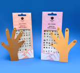 Twee verpakkingen nagelstickers met kartonnen handen met versierde nagels tegen een blauwe achtergrond.