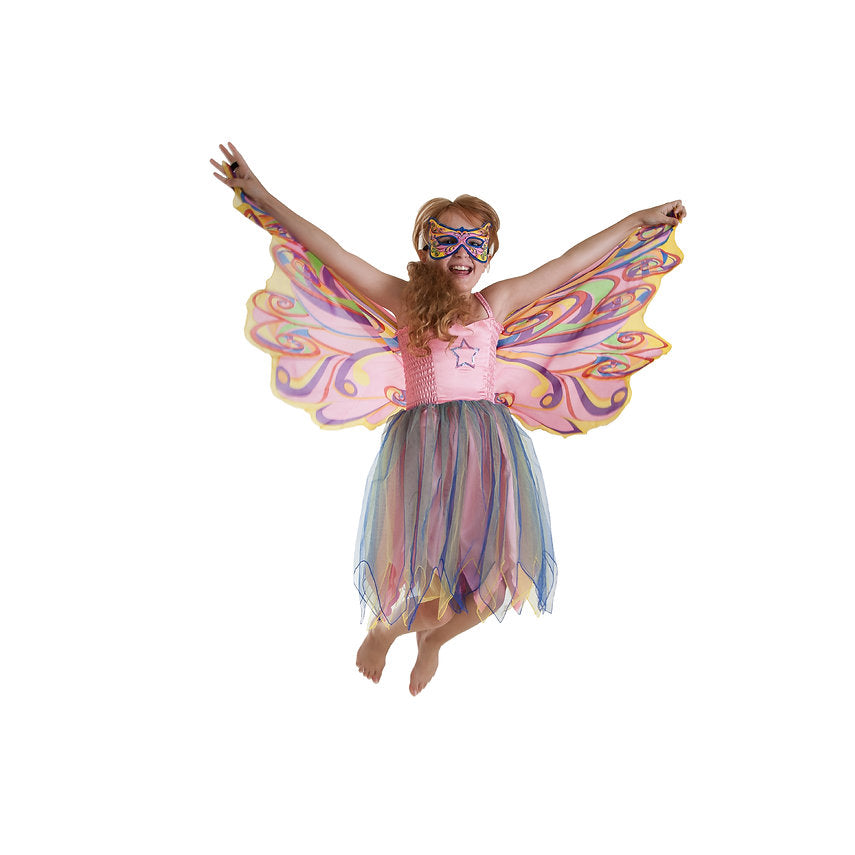Kind in regenboogjurk met roze bovenstuk, meerkleurige rok en masker, met de vlindervleugels wijd uitgespreid.