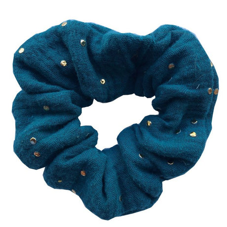 Petrolblauwe scrunchie met gouden spatjes op een witte achtergrond