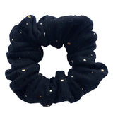 Zwarte scrunchie met gouden spatjes op een witte achtergrond