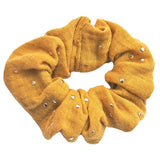 Okergele scrunchie van hydrofiel katoen met gouden spatjes.