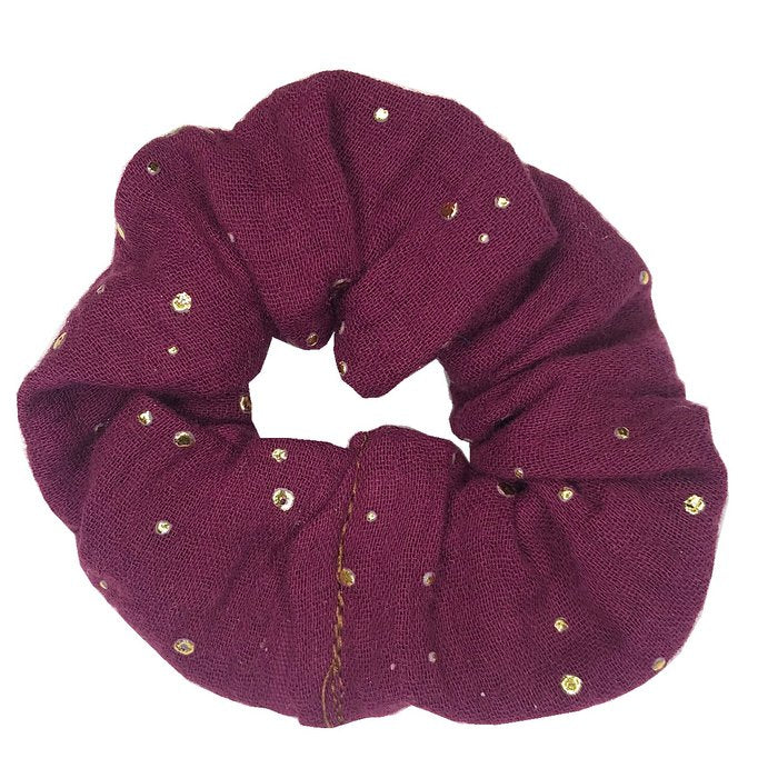 Donkerpaarse scrunchie van hydrofiel katoen met gouden spatjes.