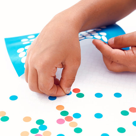 Handen plakken gekleurde ronde stickers op de DIY-poster