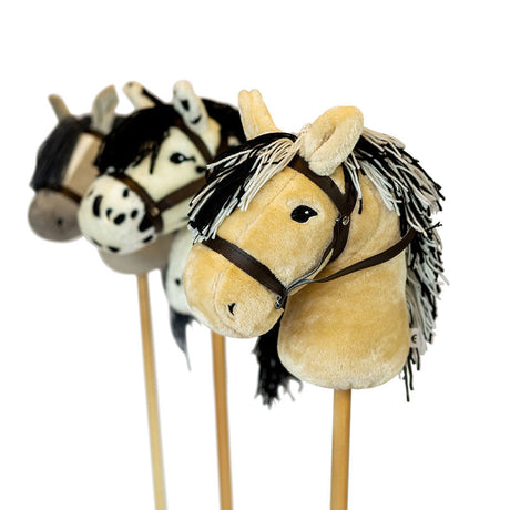 Blond stokpaardje met zwart-witte manen en bruin hoofdstel, met andere kleuren op de achtergrond.