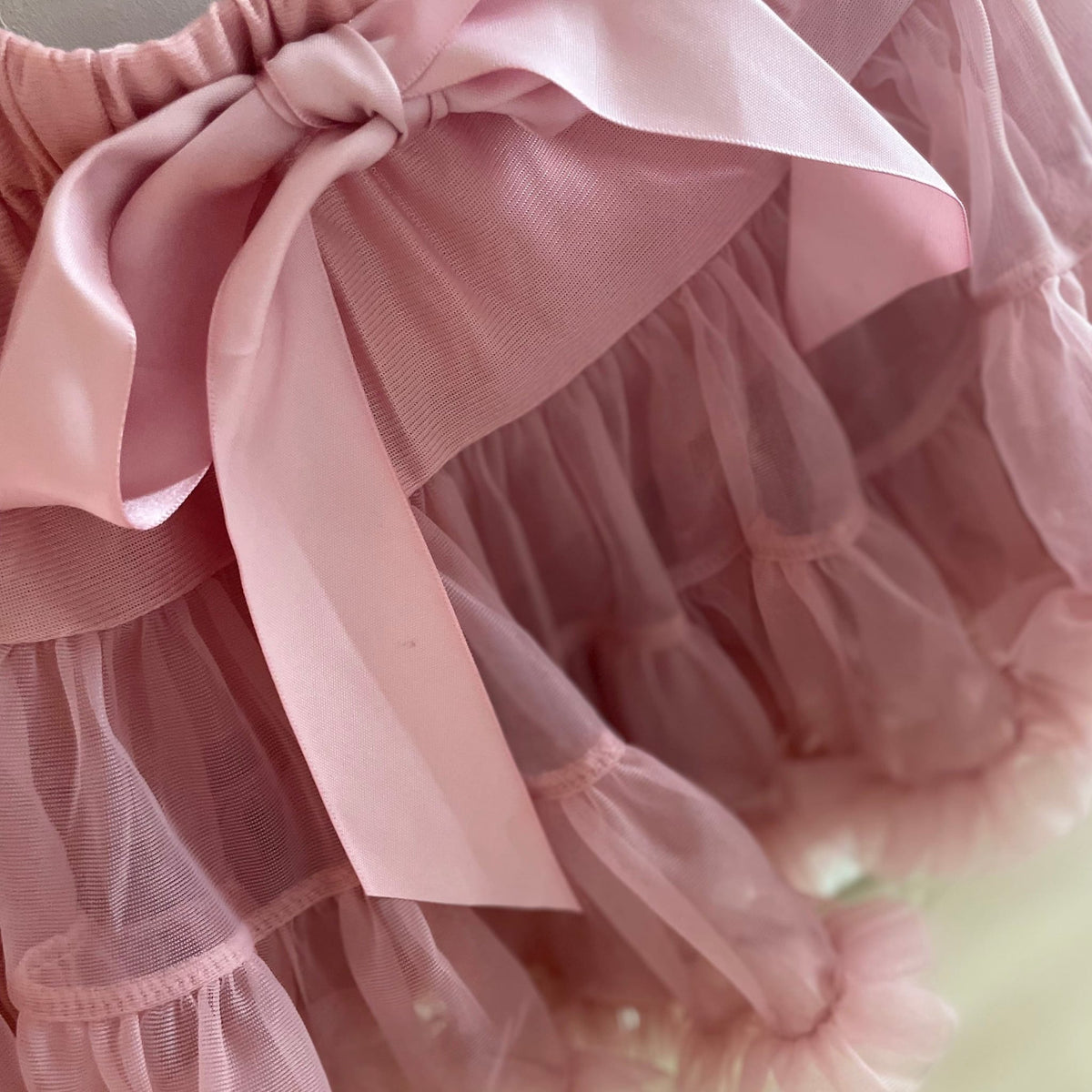 Detail van de roze Loli tutu rok met een grote strik aan de taille en laagjes ruches.