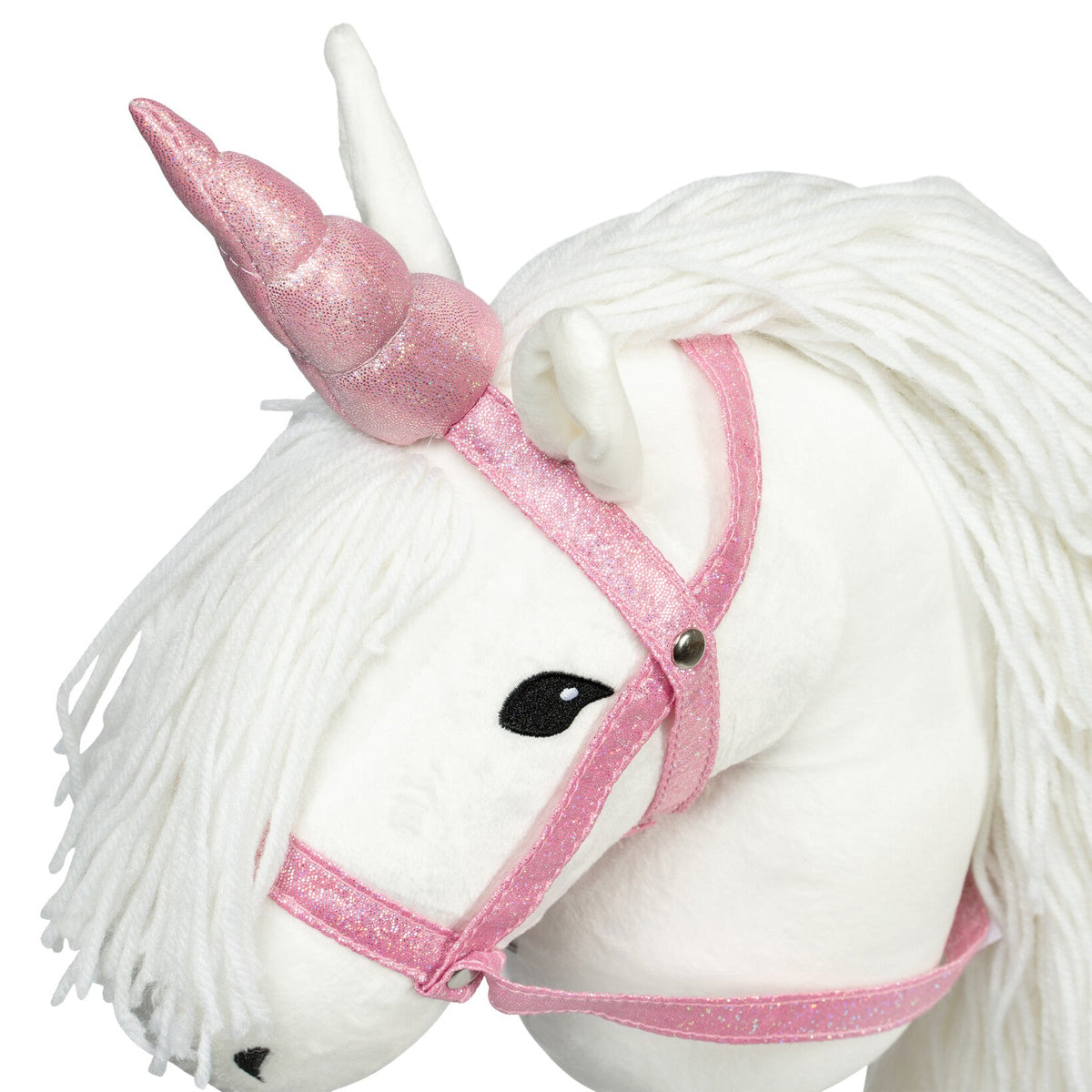 Detail van een roze glitterhoorn en halster op een wit stokpaard met witte manen